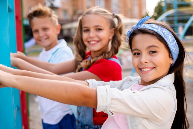 Foto gratuita niños sonrientes jugando en un patio de recreo