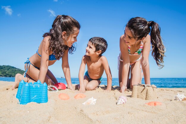 Niños sonrientes jugando en la playa