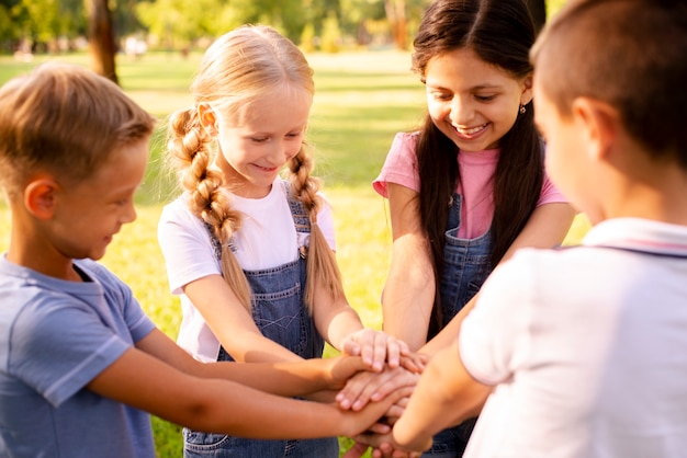 Niños sonrientes juntando sus manos