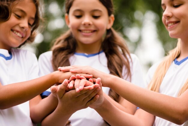 Niños sonrientes poniendo sus manos uno sobre el otro