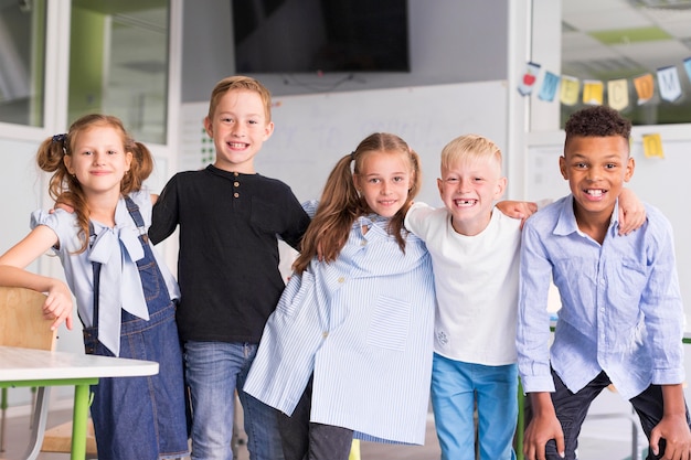 Niños sonrientes posando juntos en clase