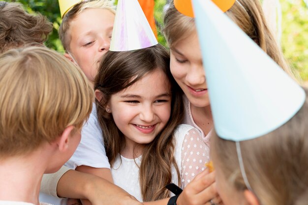 Niños sonrientes con sombreros de fiesta de cerca