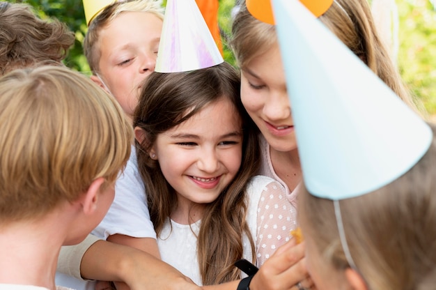 Niños sonrientes con sombreros de fiesta de cerca