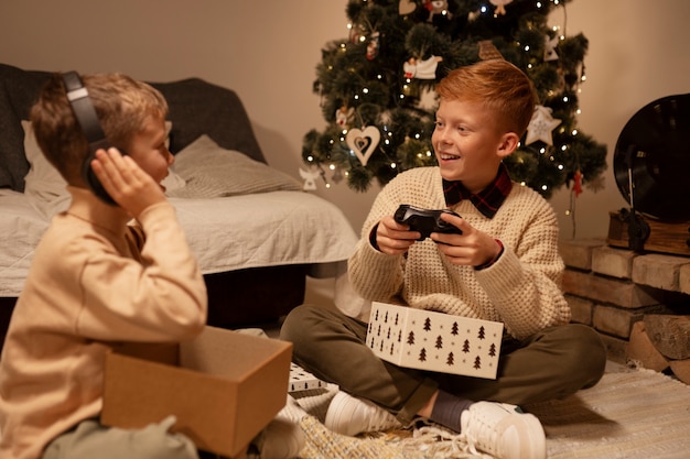 Foto gratuita niños sonrientes de tiro completo abriendo regalos