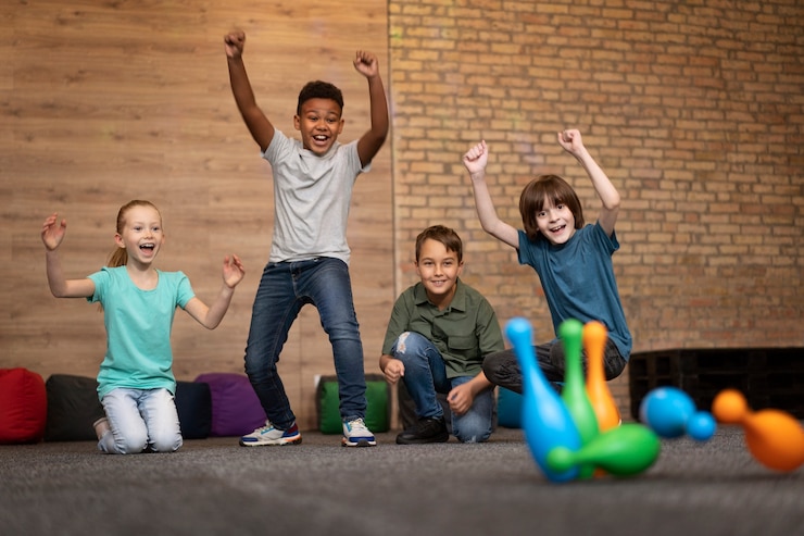 Foto gratuito niños sonrientes de tiro completo jugando bolos