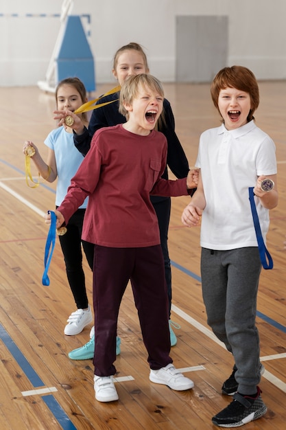 Niños sonrientes de tiro completo con medallas