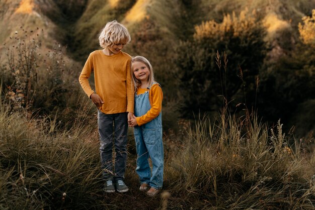 Niños sonrientes de tiro completo en la naturaleza