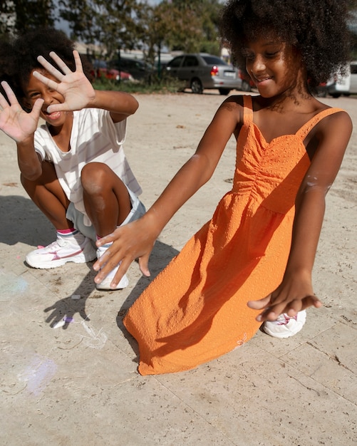 Foto gratuita niños sonrientes de tiro completo en la playa