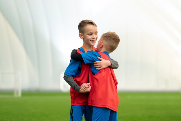 Niños sonrientes de tiro medio abrazándose