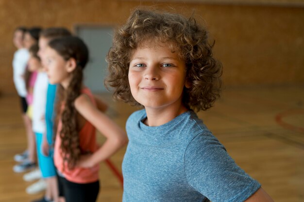 Niños sonrientes de tiro medio en el gimnasio de la escuela