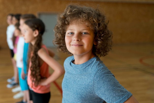 Niños sonrientes de tiro medio en el gimnasio de la escuela