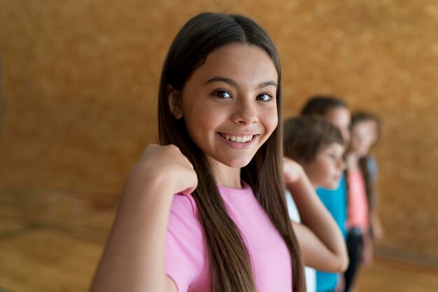 Niños sonrientes de tiro medio en el gimnasio de la escuela