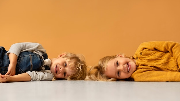 Foto gratuita niños sonrientes de tiro medio posando en el estudio