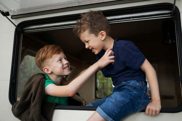 Niños sonrientes de vista lateral en autocaravana