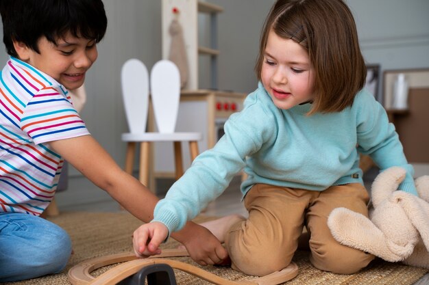 Foto gratuita niños sonrientes de vista lateral jugando juntos