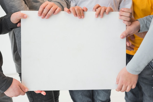 Foto gratuita niños sosteniendo cartel vacío