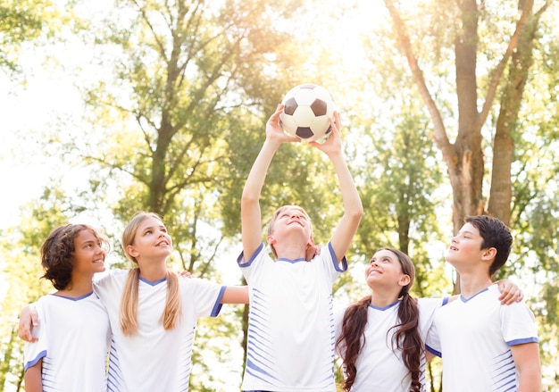 Niños sosteniendo una pelota de fútbol