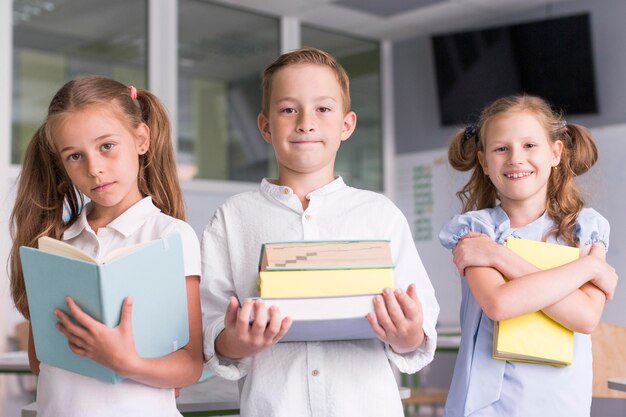 Niños sosteniendo sus libros en el aula.