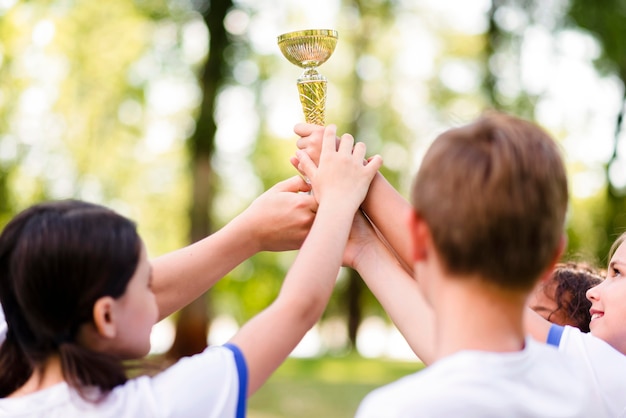 Foto gratuita niños sosteniendo un trofeo de oro.