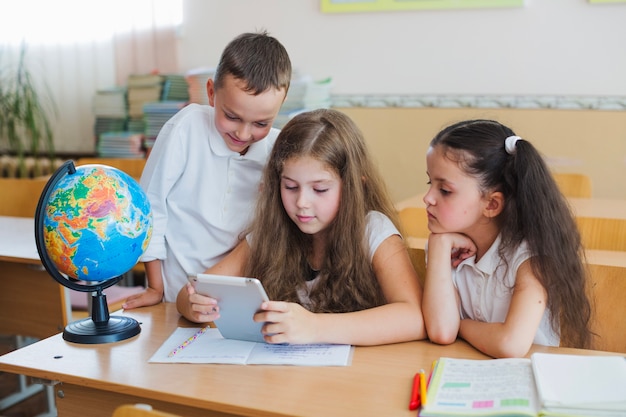 Niños con tableta en la mesa