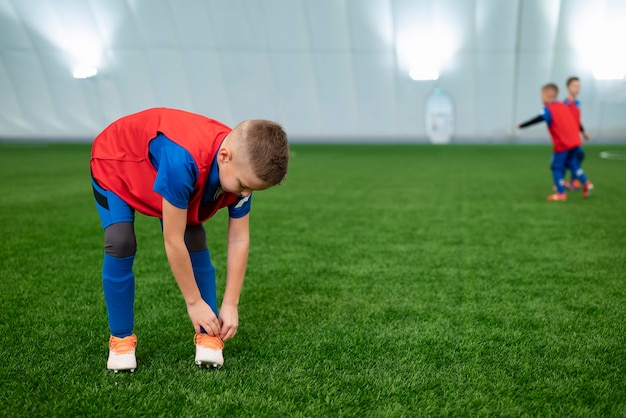 Niños de tiro completo en el campo de fútbol