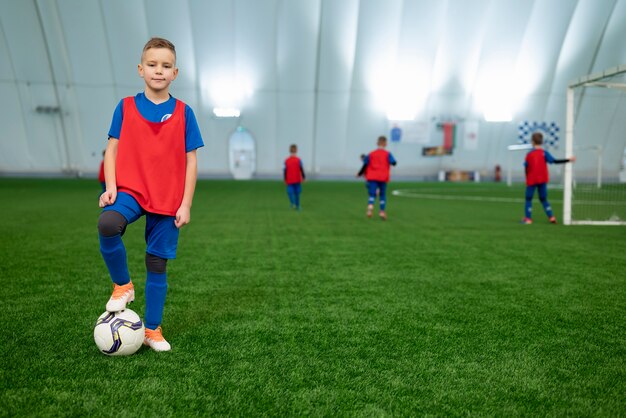 Niños de tiro completo en el campo de fútbol