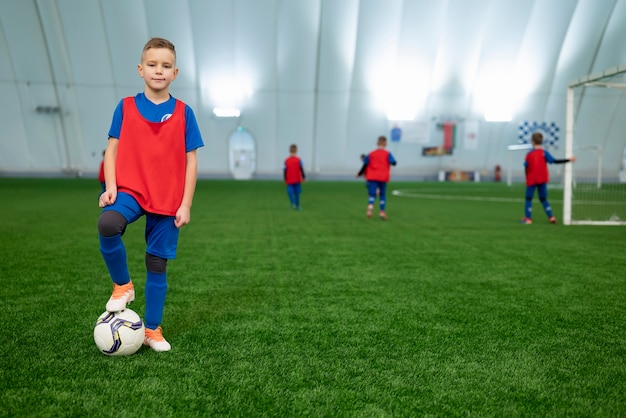 Niños de tiro completo en el campo de fútbol