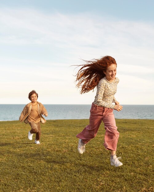 Niños de tiro completo corriendo al aire libre