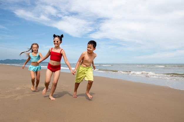 Niños de tiro completo corriendo en la playa