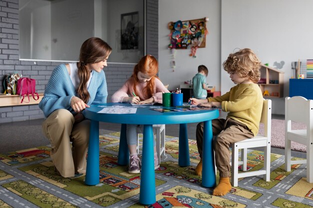 Niños de tiro completo dibujando juntos en la mesa