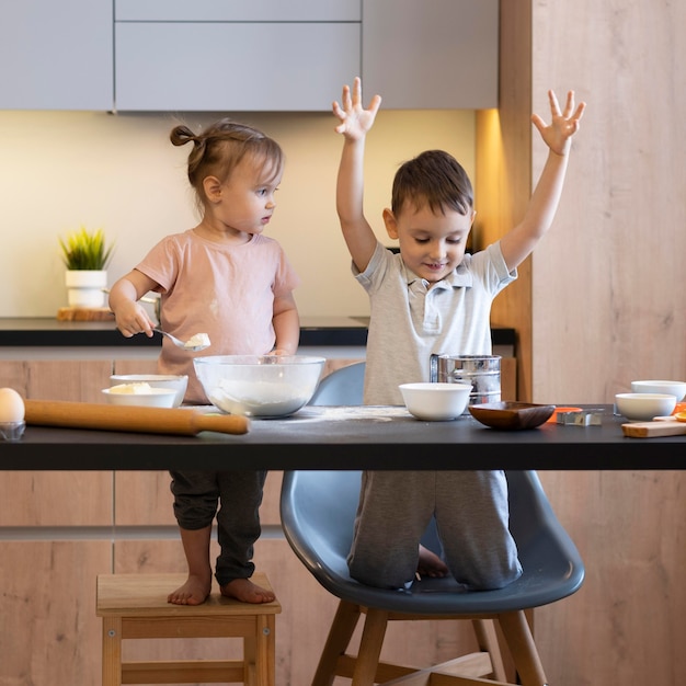 Foto gratuita niños de tiro completo divirtiéndose en la cocina