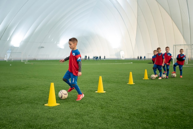 Foto gratuita niños de tiro completo entrenando en el campo