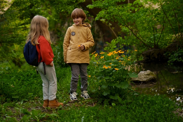 Niños de tiro completo explorando la naturaleza juntos