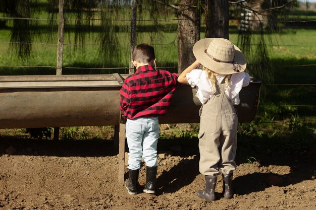 Niños de tiro completo en la granja