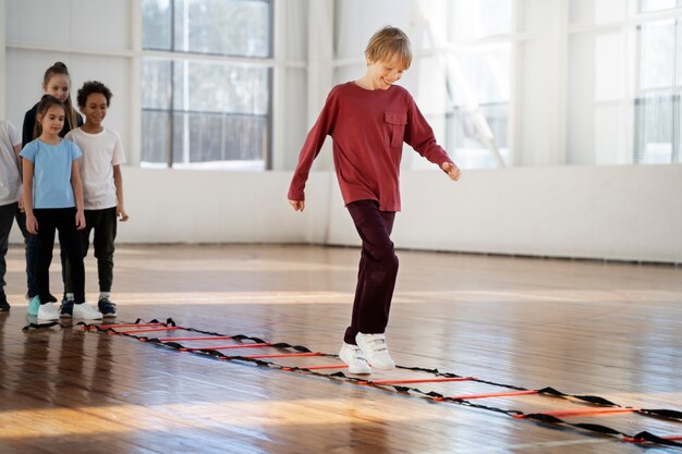 Niños de tiro completo haciendo ejercicio en el gimnasio