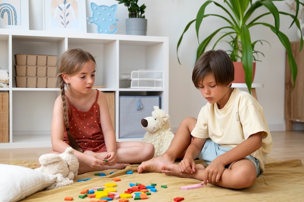 Niños de tiro completo haciendo rompecabezas juntos