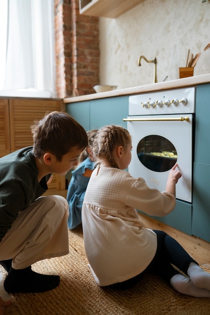 Foto gratuita niños de tiro completo horneando galletas