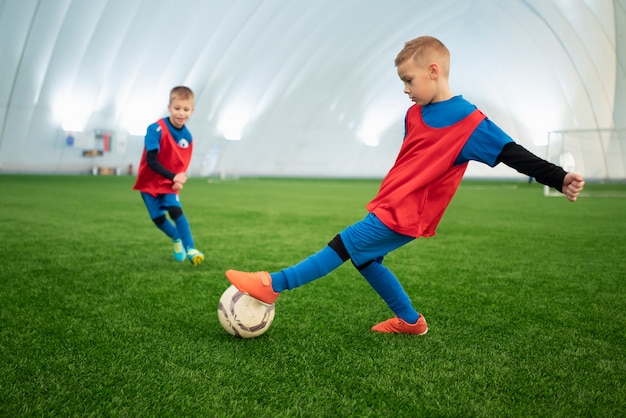 Foto gratuita niños de tiro completo jugando al fútbol.