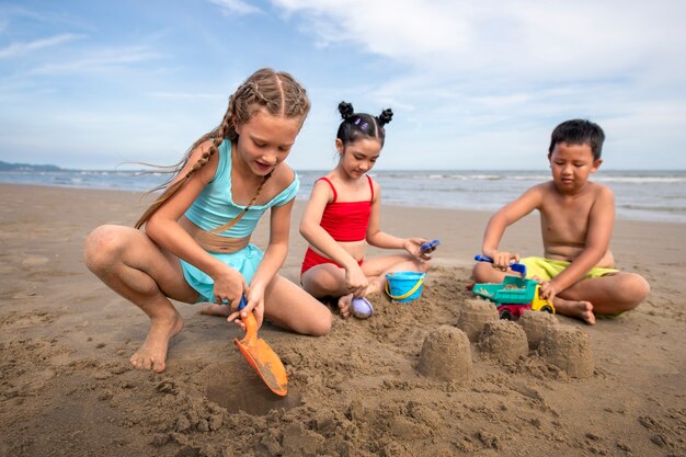 Niños de tiro completo jugando con arena.