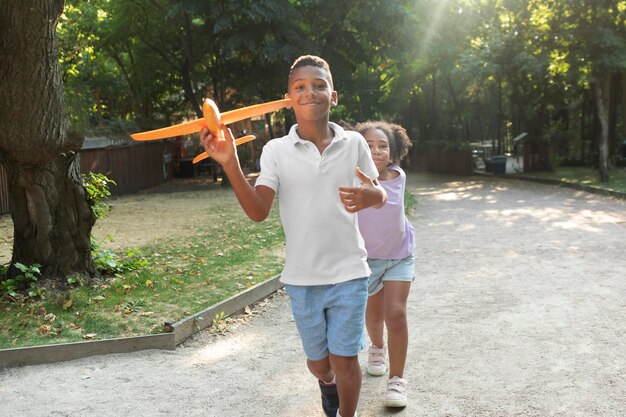 Niños de tiro completo jugando con avión