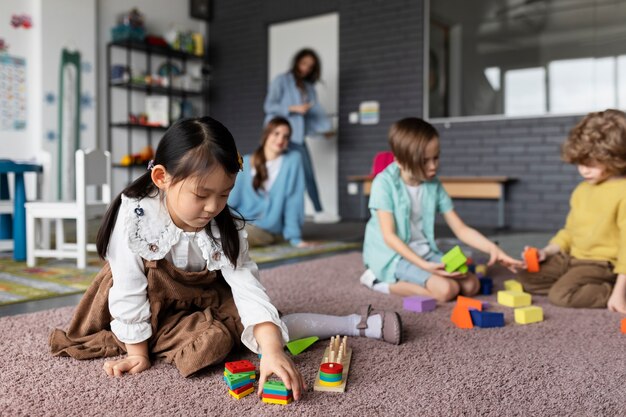 Niños de tiro completo jugando juntos en el jardín de infantes