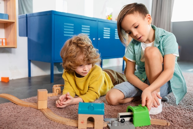 Niños de tiro completo jugando juntos con tren