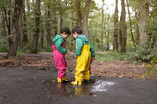 Niños de tiro completo jugando en la naturaleza.