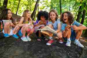 Foto gratuita niños de tiro completo con libro al aire libre