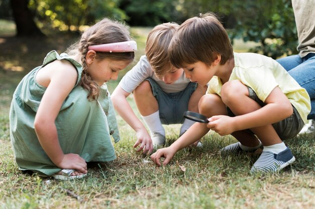 Niños de tiro completo con lupa