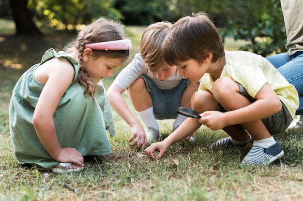 Niños de tiro completo con lupa