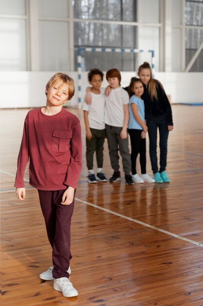 Niños de tiro completo posando en el gimnasio