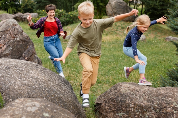 Foto gratuita niños de tiro completo saltando sobre rocas