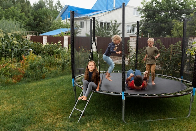 Niños de tiro completo saltando en trampolín