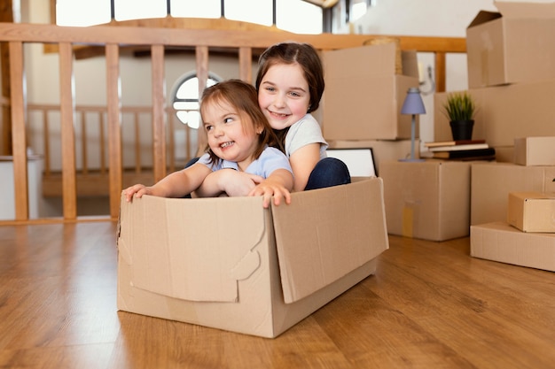 Niños de tiro completo sentados en caja